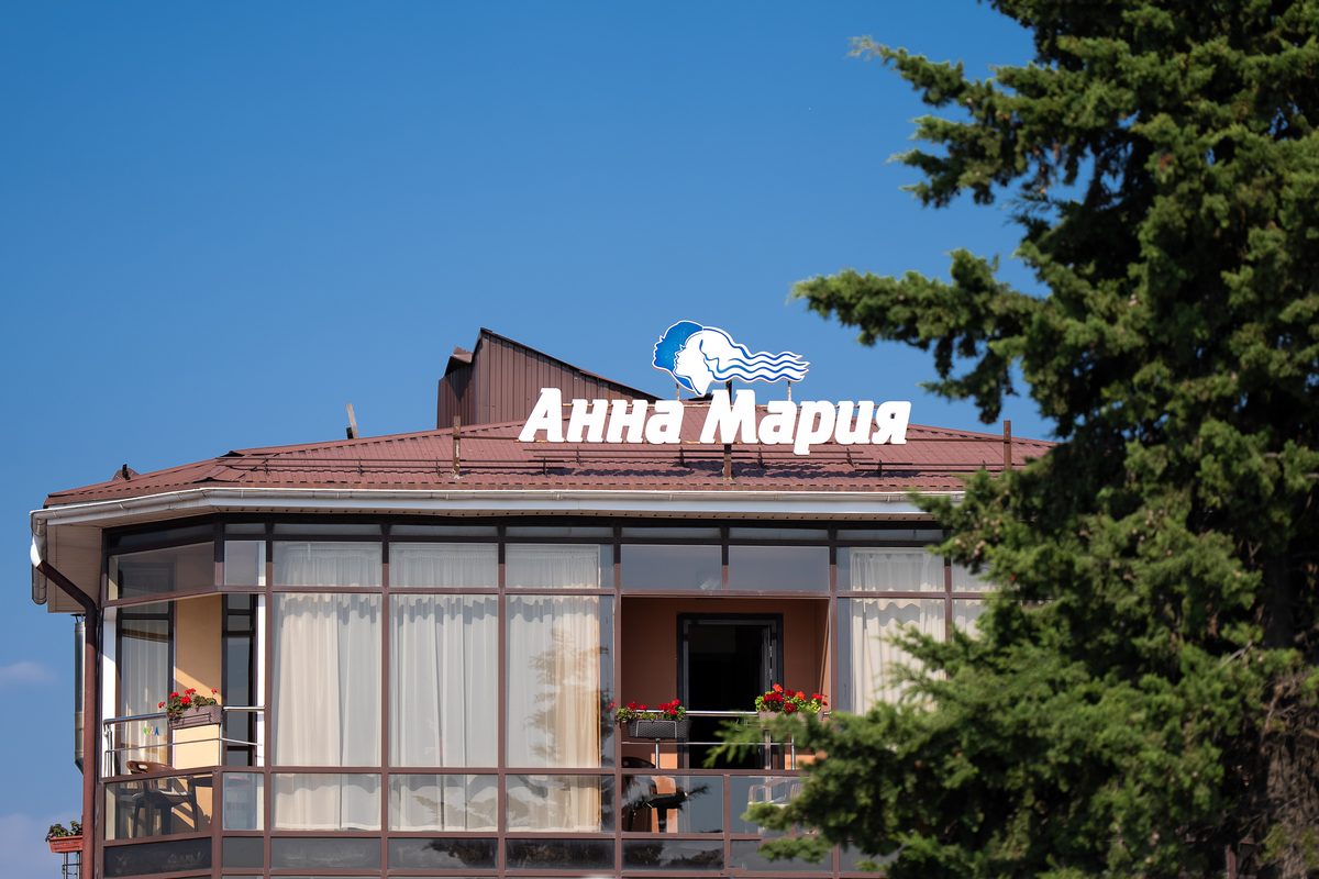 Вывеска «Анна Мария» на крыше гостевого дома